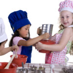 Kids playing in the kitchen using their fundraising cookbook