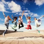 youth group members jumping for joy over their cookbook fundraiser